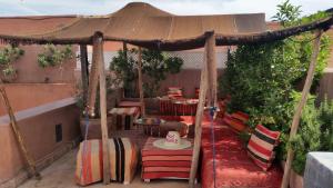 patio z altaną ze stołem i krzesłami w obiekcie Riad Vendôme & Spa w Marakeszu