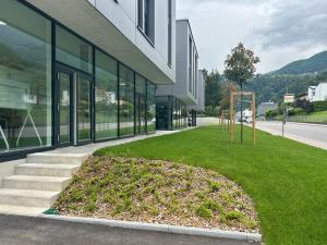 a building with a grass yard in front of a building at LabPark design apartment in Melano