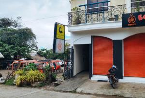 a motorcycle parked in front of a building with red doors at RedDoorz @ near Caticlan Port in Aklan