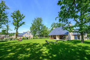 a house in the middle of a grassy yard with a bench at Les Dryades - Villa familiale proche plage in Sarzeau