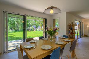 a dining room with a wooden table and chairs at Les Dryades - Villa familiale proche plage in Sarzeau