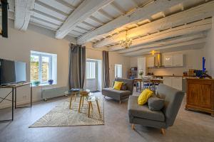 sala de estar con 2 sofás y cocina en Le Stevan - Maisonnette en duplex campagne vannetaise, en Grand-Champ