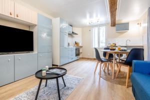 een woonkamer met een blauwe bank en een tafel bij La Perle de Laigneville - Proche Parc Astérix & Chantilly, parking public gratuit, Wifi & Netflix 