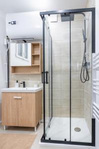 um chuveiro com uma porta de vidro na casa de banho em La Perle de Laigneville - Proche Parc Astérix & Chantilly, parking public gratuit, Wifi & Netflix 