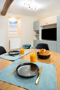a table with two plates and two glasses of orange juice at La Perle de Laigneville - Idéal pro - Netflix - Proche Parc Astérix & Chantilly - Parking public gratuit - Wifi in Laigneville
