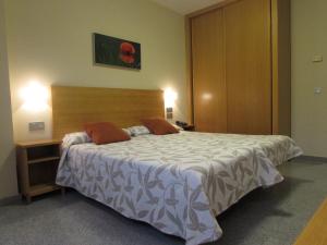 una camera da letto con un grande letto con due cuscini sopra di Hotel Palacio de Asturias a Oviedo
