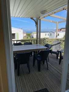 a table and chairs on the deck of a house at Mobil-Home VUE sur MER in Le Portel