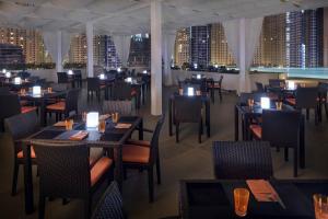 a restaurant with tables and chairs and a view of the city at Spacious, Modern Studio in Marina Dubai in Dubai