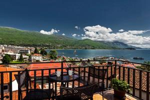 a balcony with a table and chairs and a body of water at INES APARTMENTS in Ohrid