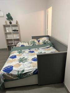 sypialnia z łóżkiem z kołdrą kwiatową w obiekcie Appartement près de La défense w mieście Nanterre