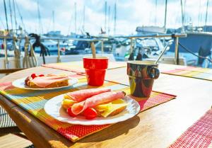 a table with two plates of food and a hot dog at One day Sailing Tour San Teodoro Sardinia in Puntaldia