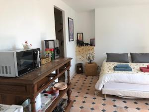 1 dormitorio con 1 cama y mesa con TV en LA FERME DE RUSSÉ en Allonnes
