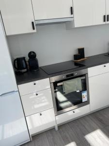 a kitchen with white cabinets and a microwave at Studio46 in Klaipėda