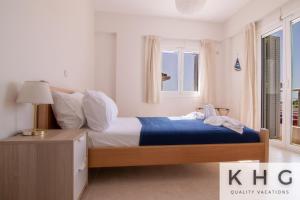 um quarto com uma cama king-size e um cobertor azul em Red Sand Apartment 1 min from Megas Lakos beach! em Lixouri