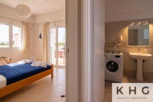 um quarto com uma cama, um lavatório e uma máquina de lavar roupa em Red Sand Apartment 1 min from Megas Lakos beach! em Lixouri