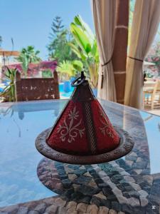 a red lamp sitting on top of a glass table at Riad Eucalyptus by Caravanserail in Essaouira