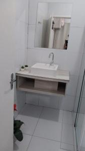a white bathroom with a sink and a mirror at Pousada Colina do Sol in Ametista do Sul