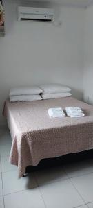 a bed with two towels on top of it at Pousada Colina do Sol in Ametista do Sul