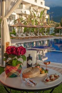 Palmonte Suites Hotel & SPA في كيرينيا: طاولة مع أطباق من الطعام بجوار حمام سباحة