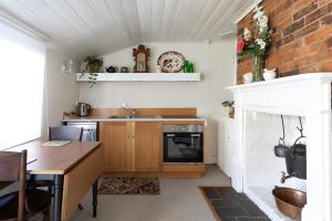 A kitchen or kitchenette at Alice's Cottages