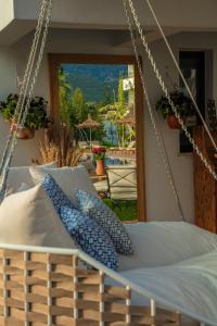 Palmonte Suites Hotel & SPA في كيرينيا: سرير مرجوح مع وسائد زرقاء أمام الفناء