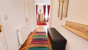 シビウにあるTelur Residenceのソファとカラフルな敷物のある廊下