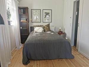 1 dormitorio con 1 cama con manta a rayas en Holiday home on Resaro only 400 m from the sea en Vaxholm