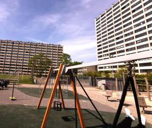 une aire de jeux en face d'un grand bâtiment dans l'établissement Midt Town Apartment Room, à Aarhus