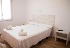 a bedroom with a white bed with two towels on it at Hotel Montemar in La Marina