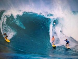 two men riding a wave on surfboards in the ocean at Doma Etxea Donostia-San Sebastian in San Sebastián