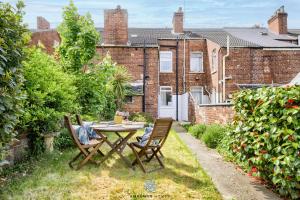 eine Terrasse mit einem Tisch und Stühlen im Garten in der Unterkunft Doncaster Large Luxury 3 Bedroom House, Sleeps 8, City Centre, Racecourse, Free Parking, by EMPOWER HOMES in Doncaster