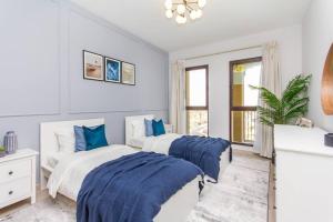 2 camas en un dormitorio con azul y blanco en Ultimate Stay / Next to Burj Al Arab / Upscale Luxury / Amazing Pool with a View / Perfect Holiday / Madinat Jumeirah / 2 BDR, en Dubái