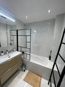 y baño con bañera y lavamanos. en Comfortable apartment with parking - Antibes Riviera en Antibes