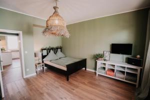 a living room with a couch and a tv at SOONWALD Studio mit Terrasse & Whirlpool in Stromberg