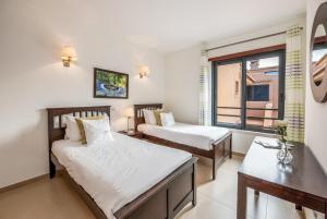 um quarto de hotel com duas camas e uma janela em Mar da Luz Resort na Praia da Luz