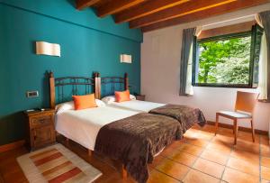 a bedroom with two beds and a window at Hotel-Apartamento Rural Atxurra in Bermeo
