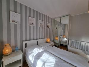 1 dormitorio con 1 cama blanca grande y espejo en visit baltic - Villa Blue Marine, en Świnoujście
