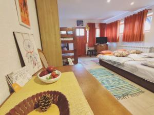 uma sala de estar com uma mesa com uma taça de fruta em Summit Apartment em Žabljak