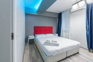 1 dormitorio con cama blanca y cabecero rojo en Bucharest City Center Apartment, en Bucarest