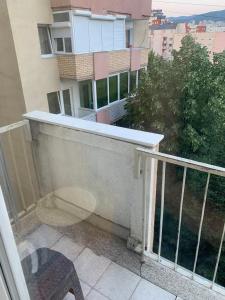 - Balcón con mesa y silla en un edificio en Comfortable apartment close to the city center, en Pristina