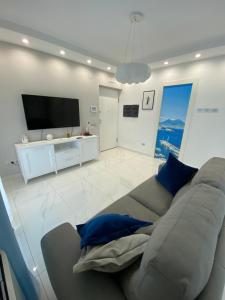 een woonkamer met een bank en een flatscreen-tv bij Simon's House in Volla