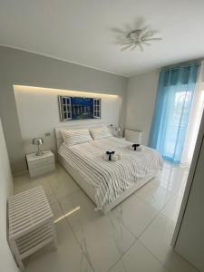 1 dormitorio blanco con 1 cama y ventilador de techo en Simon's House, en Volla