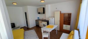 a small kitchen with a white table and a refrigerator at Къща Поморини Несебър in Nesebar
