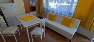 a room with a table and a bench and a table and chairs at Къща Поморини Несебър in Nesebar