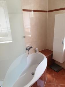een badkamer met een wit bad en een wastafel bij Ferienwohnung Nella in Amberg