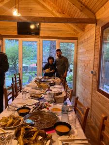 Un groupe de personnes autour d'une table avec de la nourriture dans l'établissement Bujtina Arturi, à Valbonë