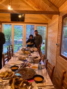 a group of people standing around a table with food at Bujtina Arturi in Valbonë