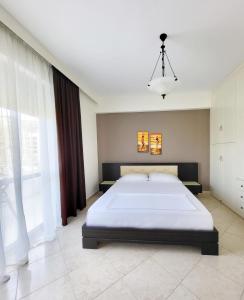 a bedroom with a large bed and a large window at SeaLaVita, Modern 2 BR Apartment Sea & Sunset View in Vlorë