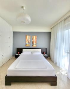 a large white bed in a room with a large window at SeaLaVita, Modern 2 BR Apartment Sea & Sunset View in Vlorë