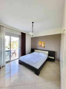 a bedroom with a large bed and a balcony at SeaLaVita, Modern 2 BR Apartment Sea & Sunset View in Vlorë